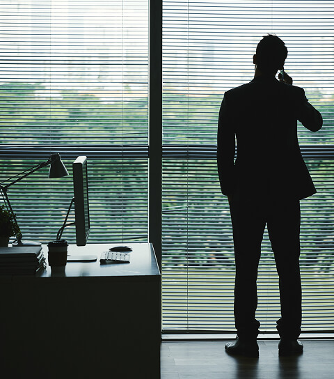 Ein Mann Im Büro Vor Dem Fenster Telefoniert