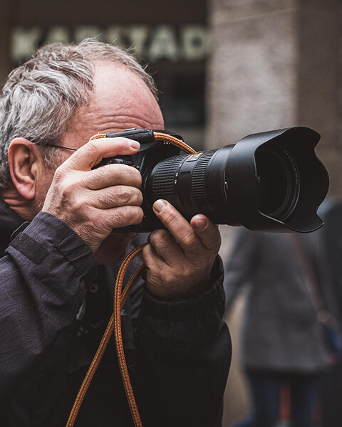 Ein Mann, der mit einer professionellen Kamera auf der Straße fotografiert