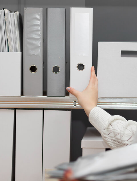 Hand Greift Nach Grauem Ordner In Einem Büroregal Mit Aktenordnern Und Dokumenten
